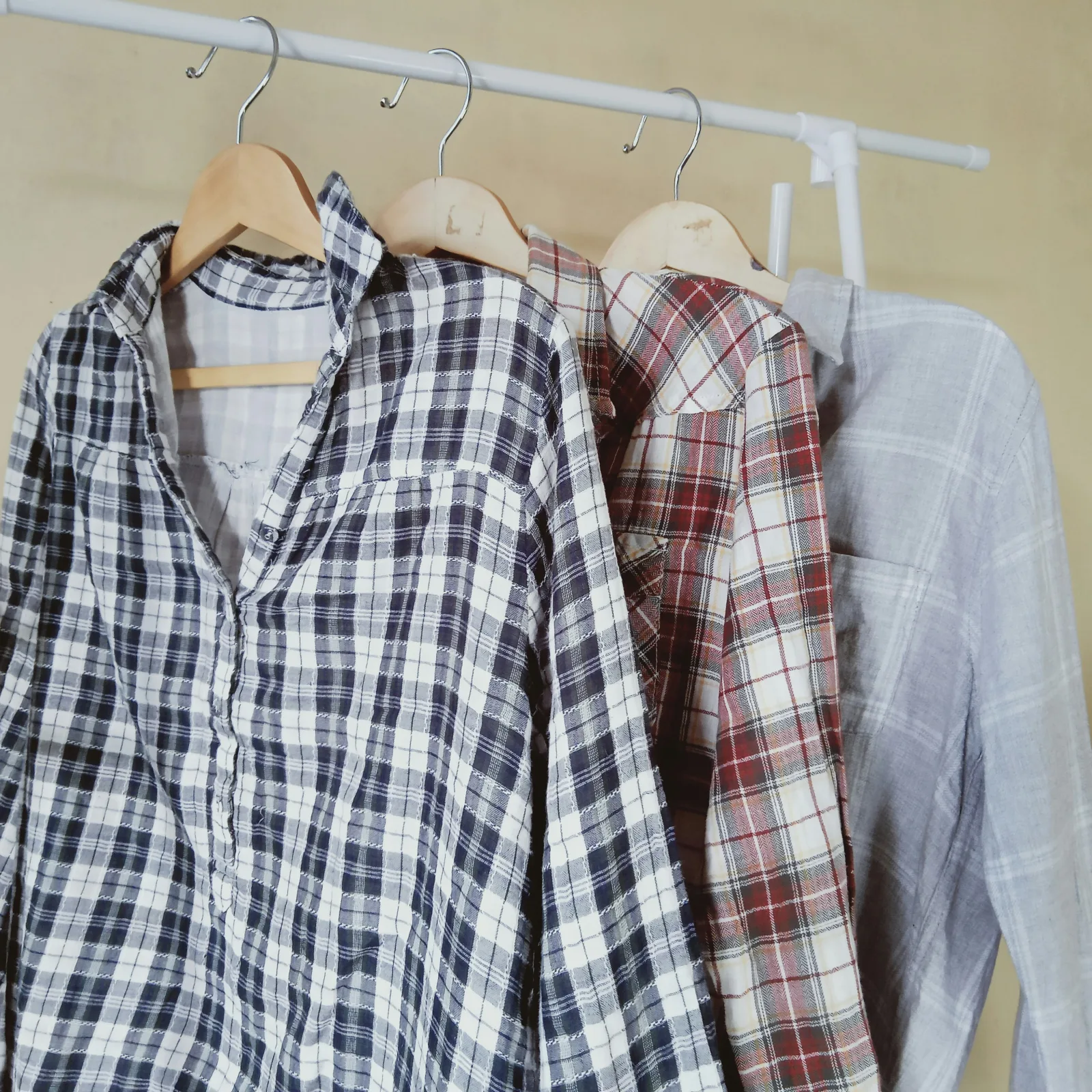 Cuatro camisas de franela a cuadros colgadas en un perchero
