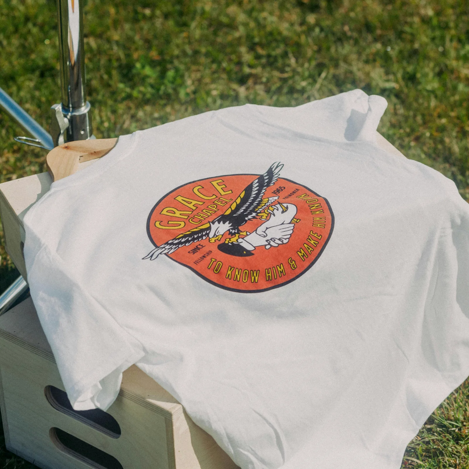 Camiseta blanca con un estampado circular naranja de un águila